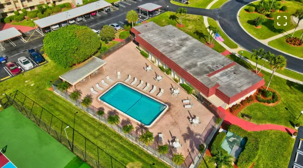 an aerial view of a multi story residential apartment building with yard and green space