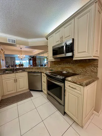 a kitchen with stainless steel appliances granite countertop a stove a sink and a microwave