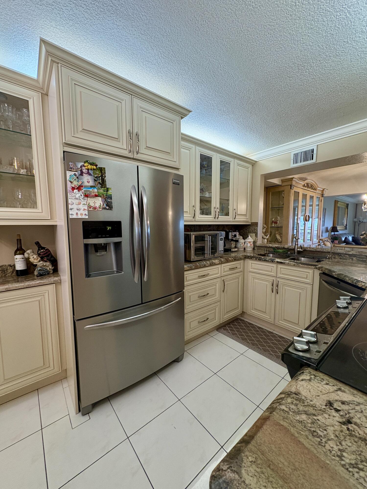 23249 Barwood Lane North, Unit 402 Boca Raton, FL 33428 - Photo 4 of 27 a kitchen with stainless steel appliances kitchen island granite countertop a refrigerator sink and cabinets