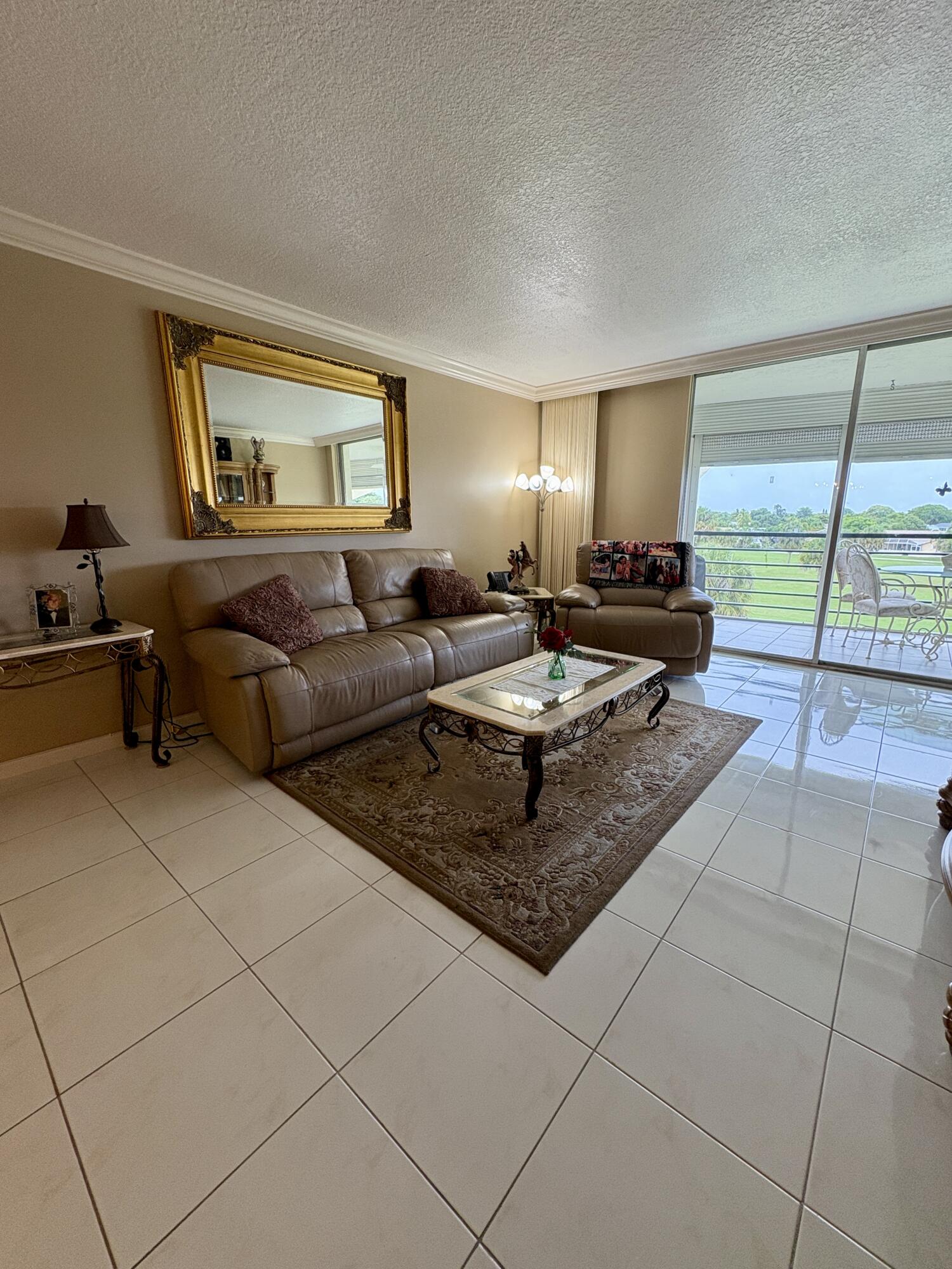23249 Barwood Lane North, Unit 402 Boca Raton, FL 33428 - Photo 5 of 27 a living room with furniture and a table