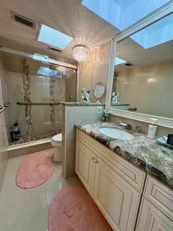 a bathroom with a granite countertop sink and a mirror