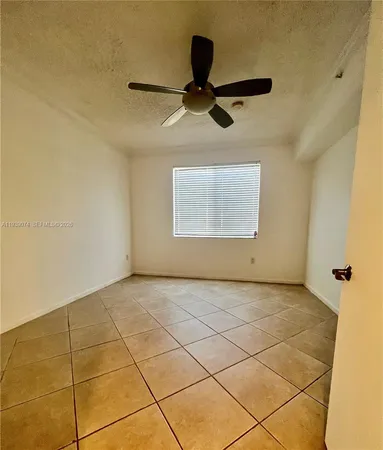 a view of a room with a ceiling fan and window