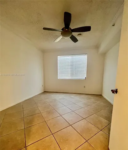a view of a room with a ceiling fan and window