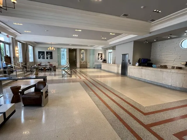 a large living room with stainless steel appliances furniture a rug and a large window