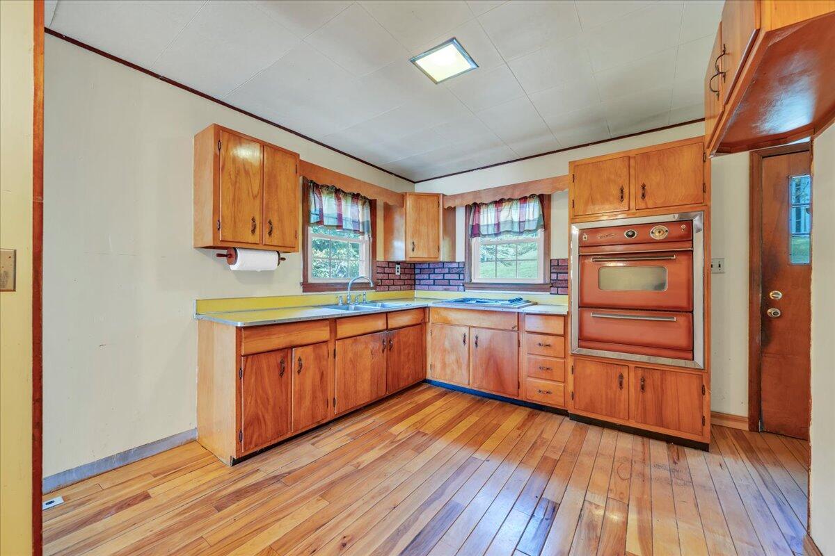 201 Long Avenue Covington, VA 24426 - Photo 10 of 43 a kitchen with granite countertop wooden floors and wide window