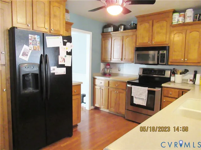 a kitchen with stainless steel appliances granite countertop a refrigerator a stove a sink and a microwave