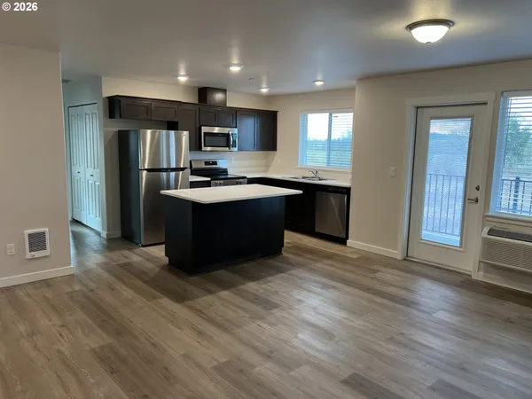 a large kitchen with stainless steel appliances granite countertop a stove and a refrigerator