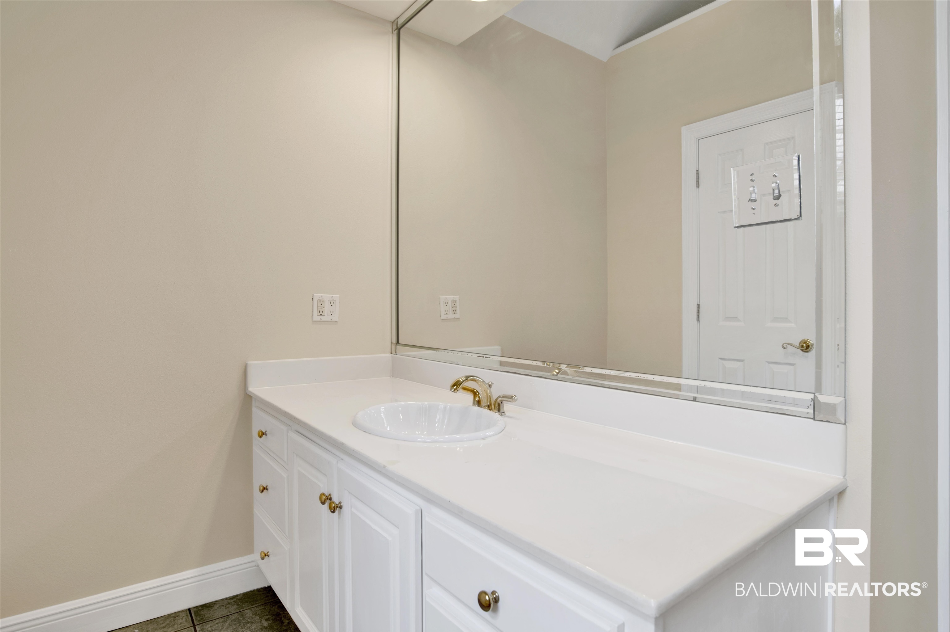 8847 Dawes Lake Road South Mobile, AL 36619 - Photo 23 of 47 Bathroom vanity featuring a white countertop, an undermount sink, and a gold-finish faucet