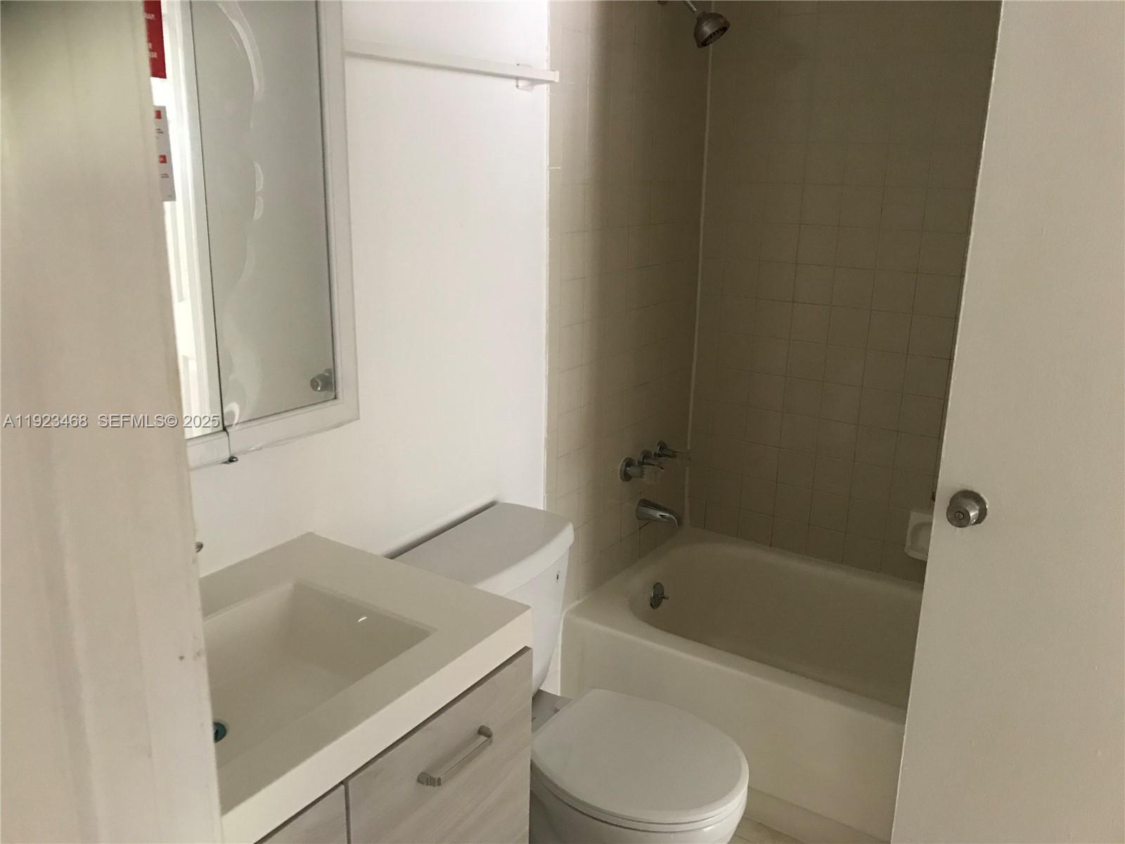 206 Northeast 3rd Street, Unit 10 Hallandale Beach, FL 33009 - Photo 2 of 6 a bathroom with a bathtub sink and toilet