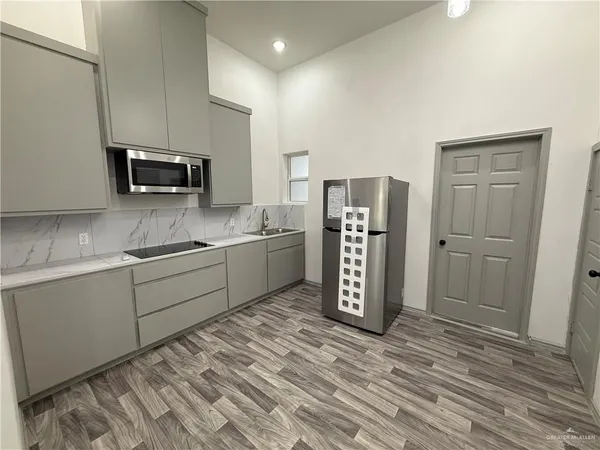 a kitchen with stainless steel appliances a refrigerator sink and microwave