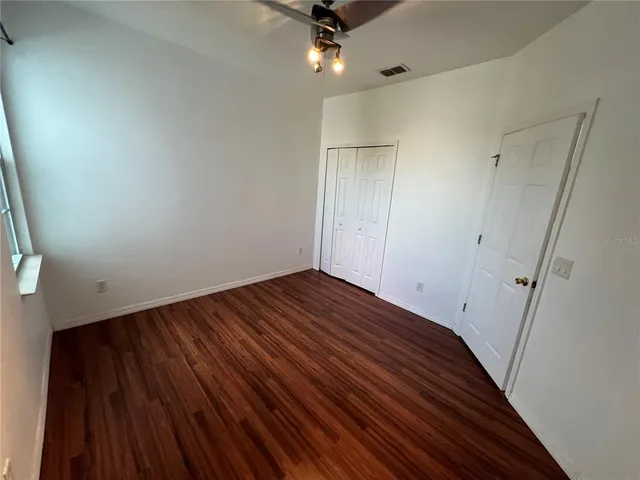 a view of empty room with wooden floor