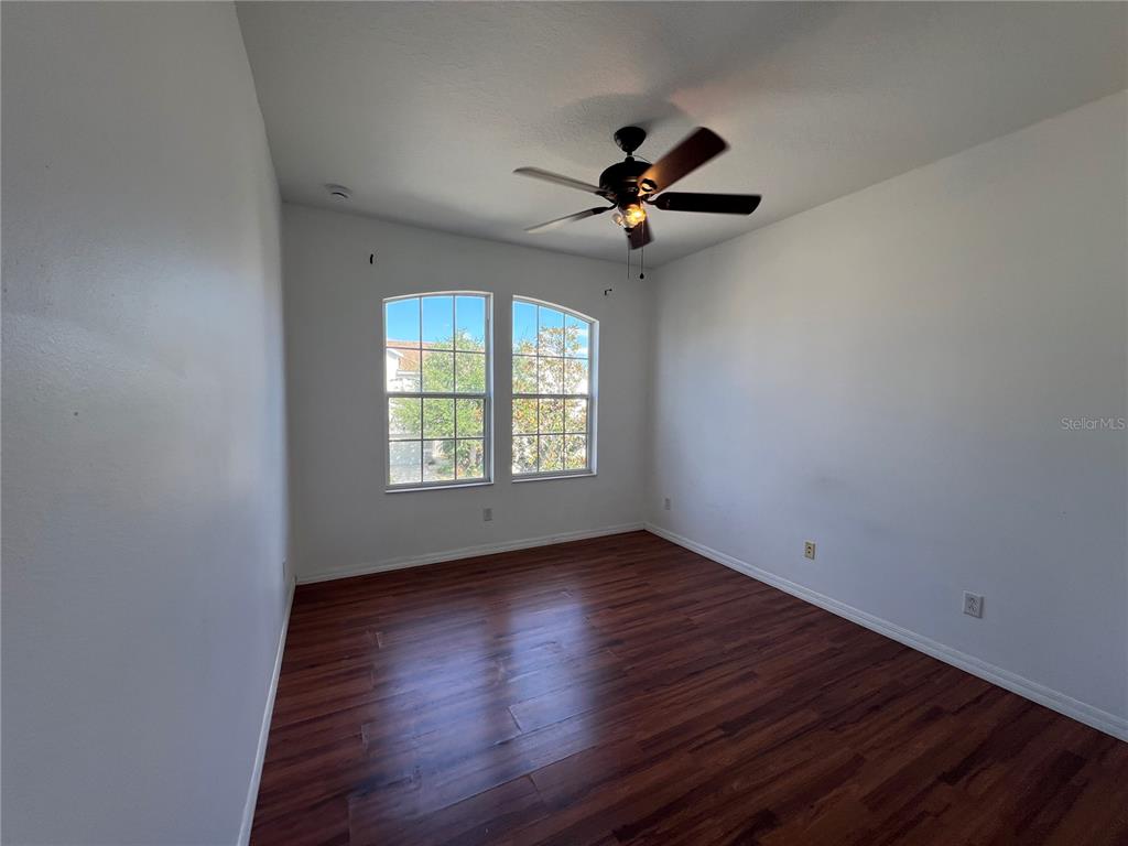 9013 Shepton Street Orlando, FL 32825 - Photo 14 of 20 an empty room with wooden floor ceiling fan and windows