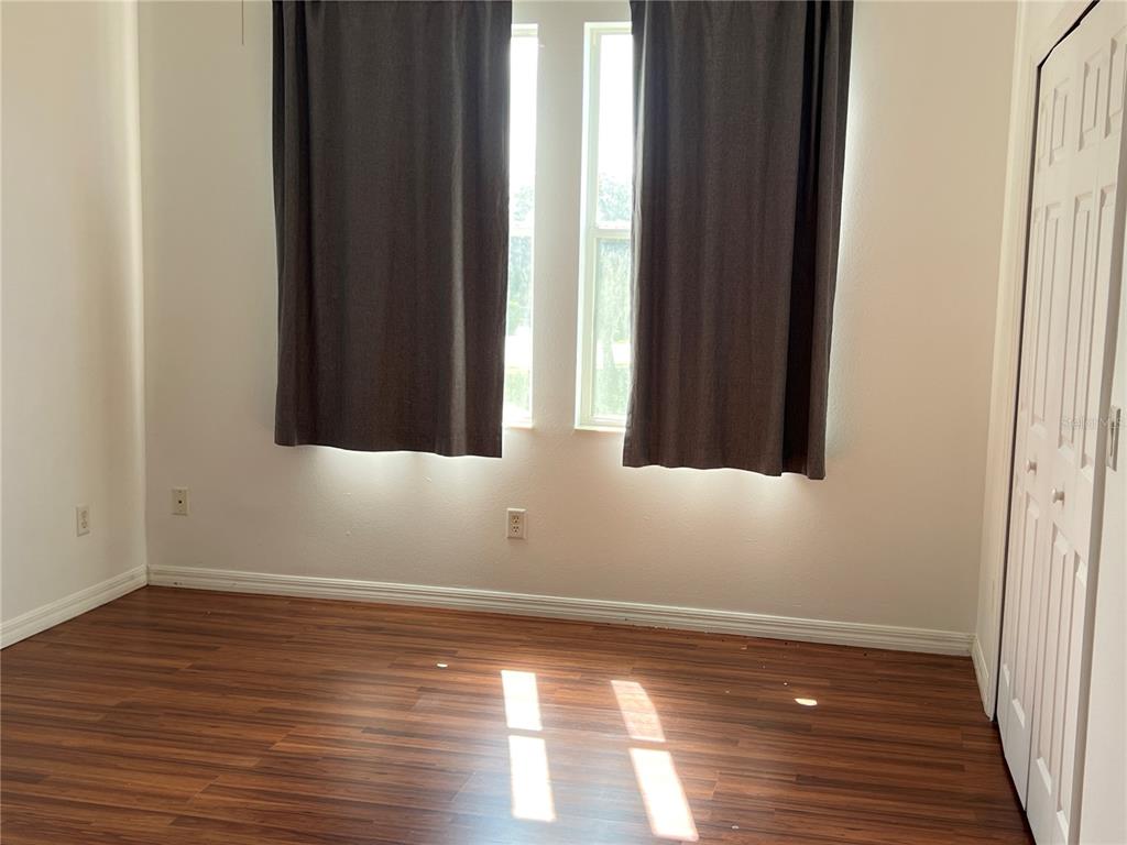 9013 Shepton Street Orlando, FL 32825 - Photo 9 of 20 a view of an empty room with wooden floor and a window
