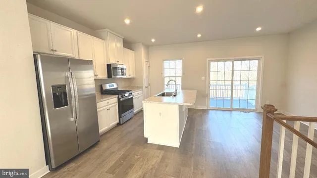 a kitchen with stainless steel appliances a sink stove and cabinets