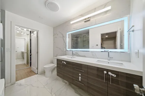 a bathroom with a double vanity sink mirror and toilet