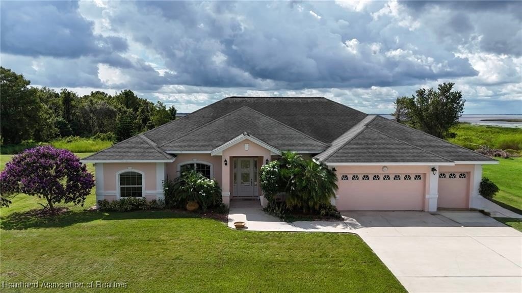 1101 Lakeside Way Sebring, FL 33876 - Photo 1 of 41 a front view of a house with a garden