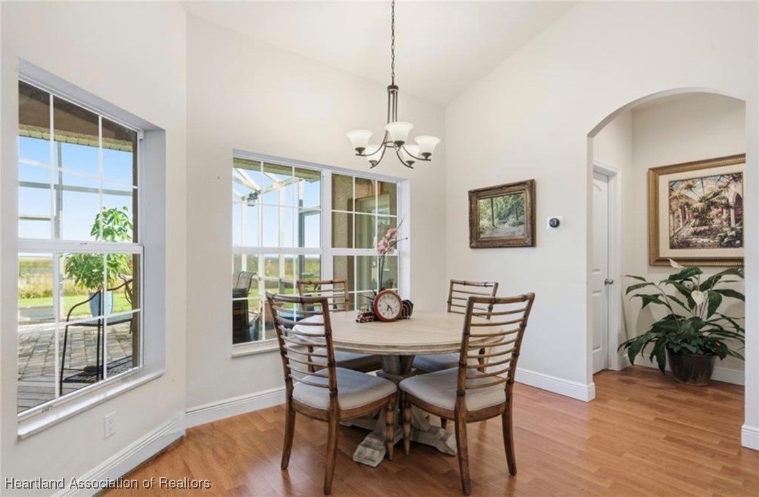 1101 Lakeside Way Sebring, FL 33876 - Photo 30 of 41 a dining room with furniture wooden floor a potted plant and a chandelier