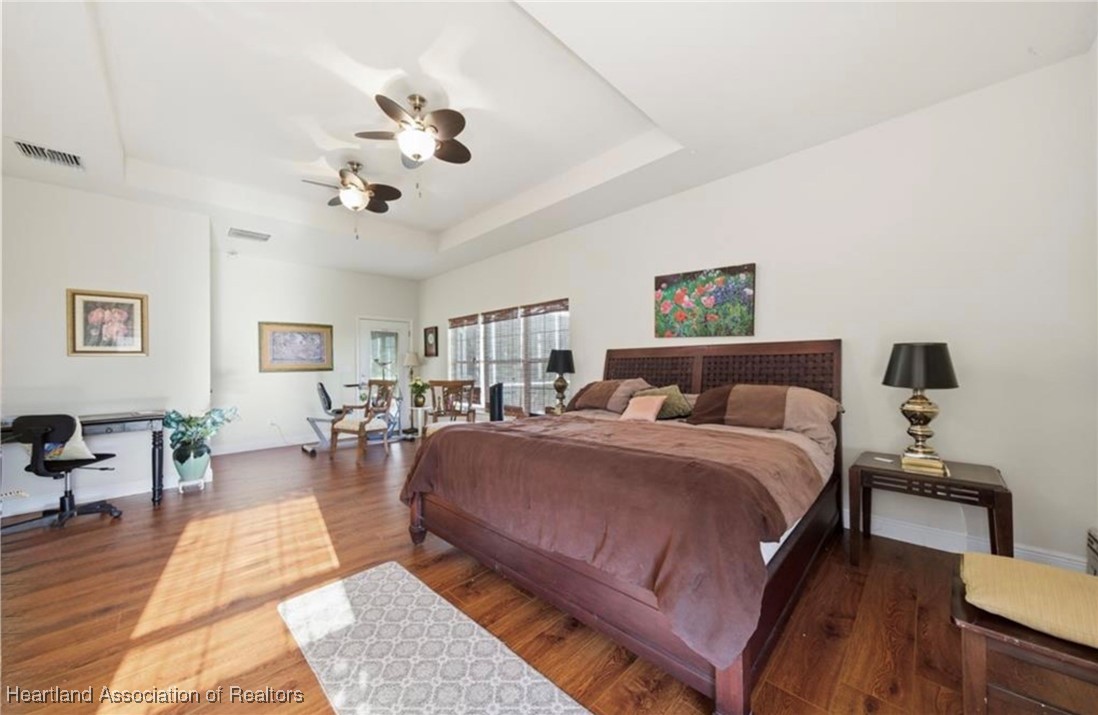 1101 Lakeside Way Sebring, FL 33876 - Photo 9 of 41 a spacious bedroom with a large bed a chandelier and windows