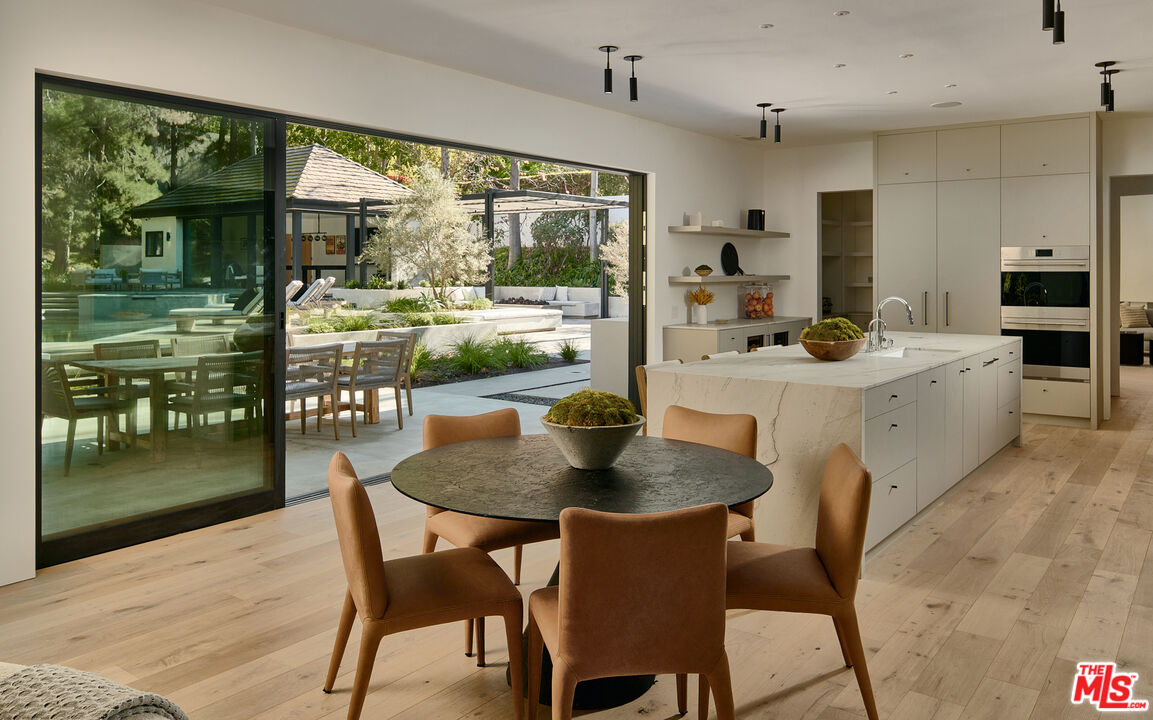 3858 Hayvenhurst Drive Encino, CA 91436 - Photo 11 of 49 a dining room with furniture a large window and a table