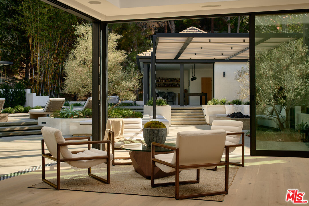 3858 Hayvenhurst Drive Encino, CA 91436 - Photo 16 of 49 a view of a patio with table and chairs and potted plants