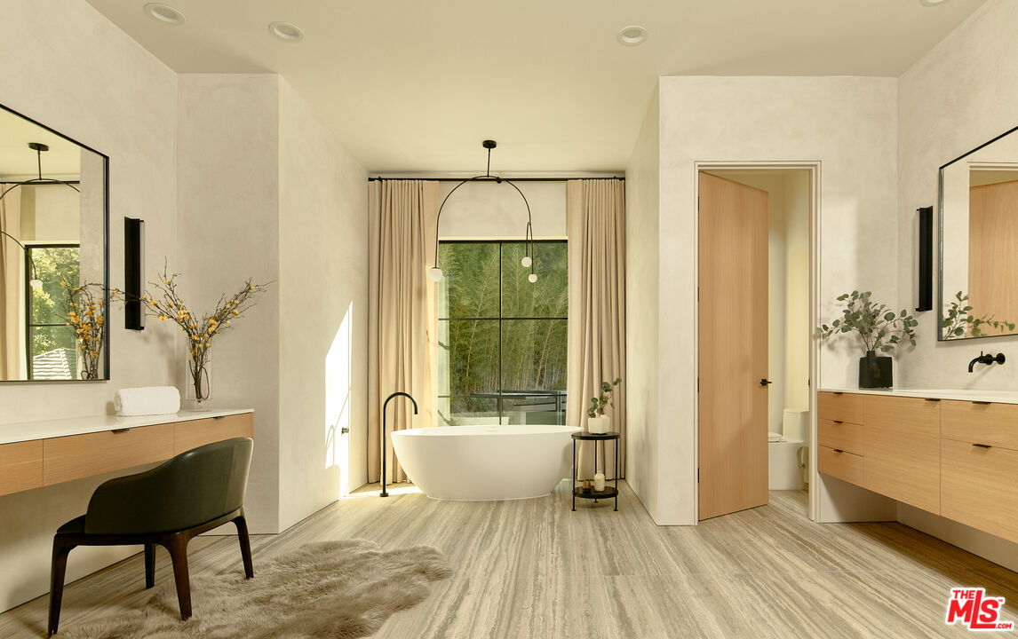 3858 Hayvenhurst Drive Encino, CA 91436 - Photo 27 of 49 a spacious bathroom with a tub shower and mirror