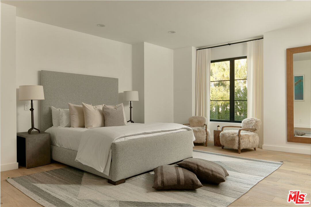 3858 Hayvenhurst Drive Encino, CA 91436 - Photo 34 of 49 a bedroom with a large bed and glass window