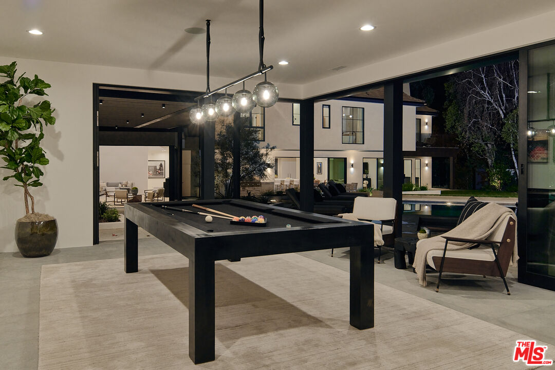 3858 Hayvenhurst Drive Encino, CA 91436 - Photo 40 of 49 a living room with furniture a table and potted plants