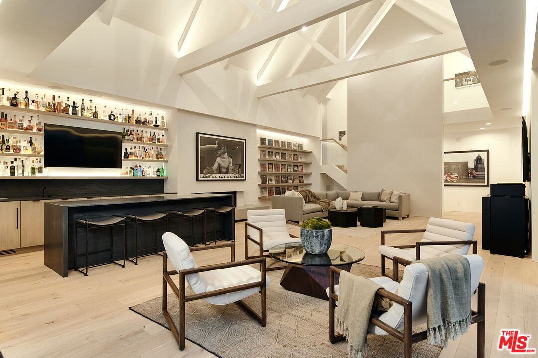 3858 Hayvenhurst Drive Encino, CA 91436 - Photo 43 of 49 a living room with furniture a flat screen tv and kitchen view