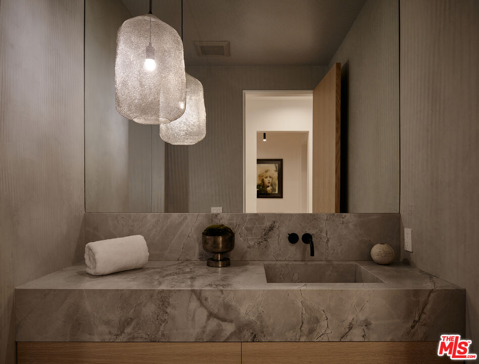 3858 Hayvenhurst Drive Encino, CA 91436 - Photo 47 of 49 a bathroom with a sink mirror and vanity