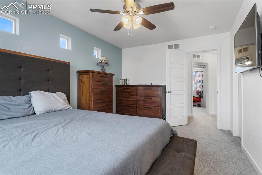 9319 Timberlake Loop Colorado Springs, CO 80927 - Photo 11 of 25 a bedroom with a large bed and a chandelier