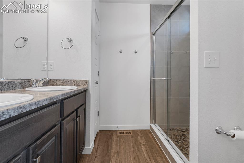 9319 Timberlake Loop Colorado Springs, CO 80927 - Photo 12 of 25 a bathroom with a granite countertop sink a mirror and shower