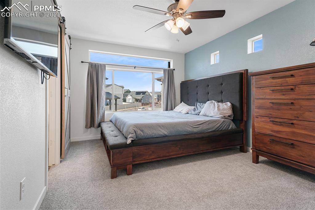 9319 Timberlake Loop Colorado Springs, CO 80927 - Photo 13 of 25 a bedroom with a bed and a chandelier