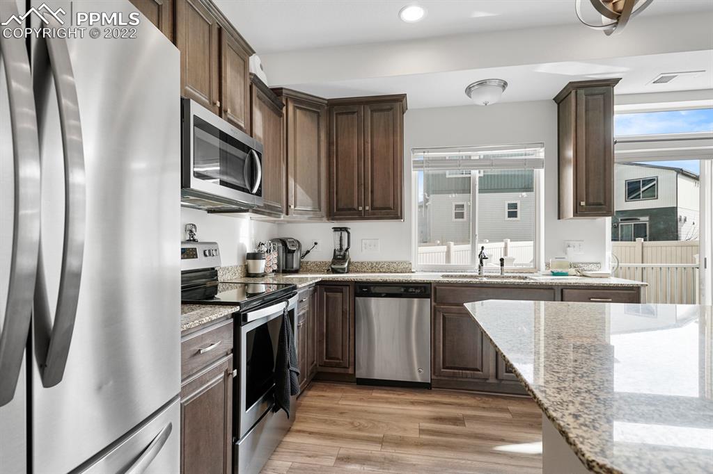 9319 Timberlake Loop Colorado Springs, CO 80927 - Photo 9 of 25 a kitchen with stainless steel appliances granite countertop a refrigerator a sink a stove and oven