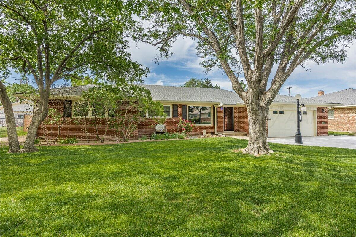 3017 Mockingbird Lane Amarillo, TX 79109 - Photo 2 of 25 a view of a yard in front of a house with large tree