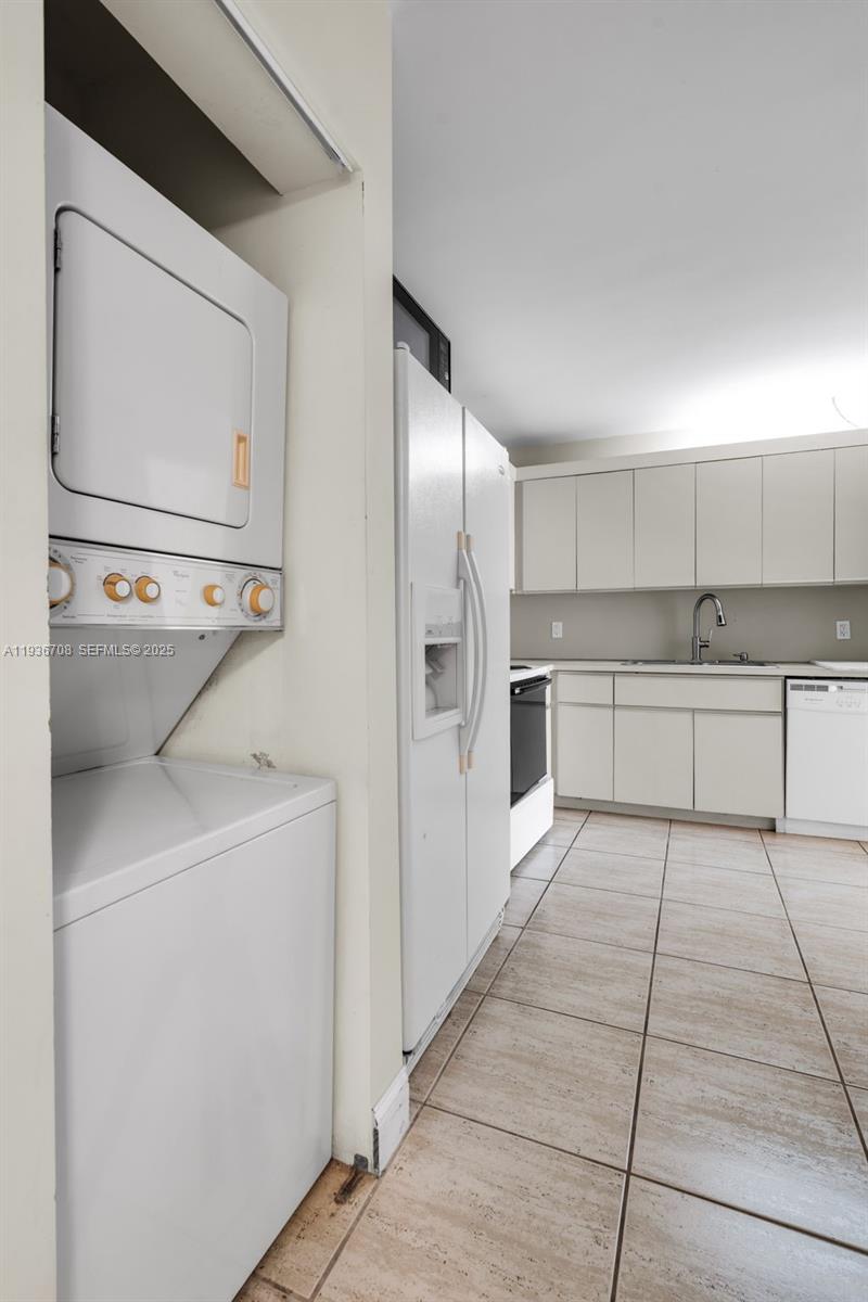 8877 Collins Avenue, Unit 303 Surfside, FL 33154 - Photo 22 of 25 a kitchen with stainless steel appliances a refrigerator sink and cabinets