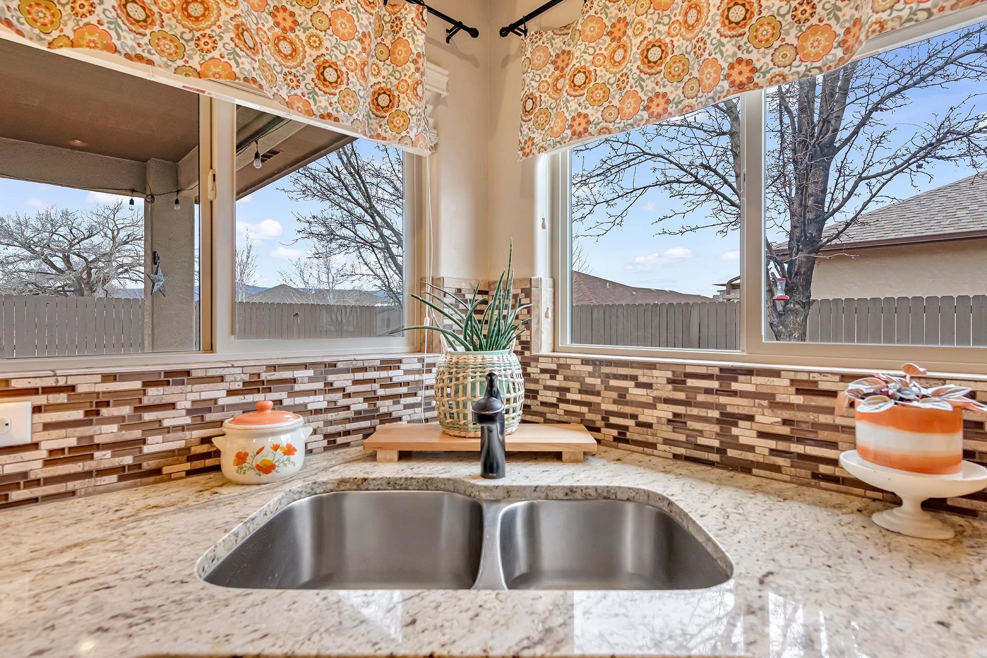 1660 Powis Lane Fruita, CO 81521 - Photo 12 of 38 a bathroom with a granite countertop sink and mirror next to a window