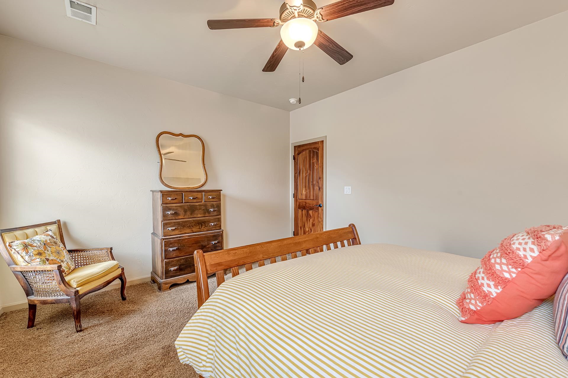 1660 Powis Lane Fruita, CO 81521 - Photo 14 of 38 a bedroom with a bed a chandelier and a chair