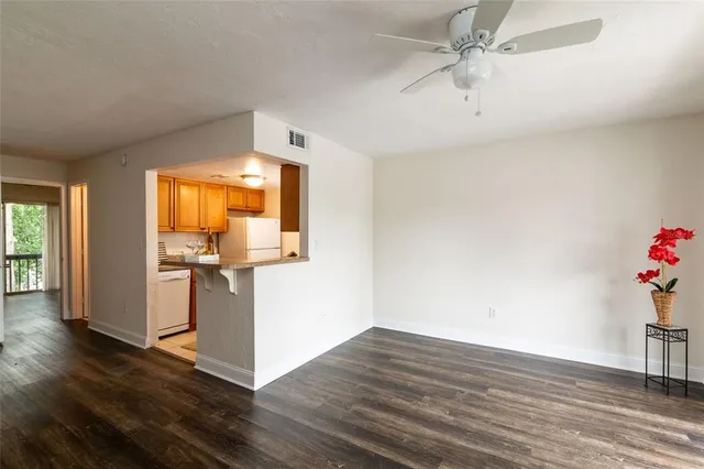 a view of a room with wooden floor and ceiling fan
