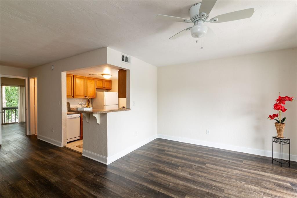 3555 Southwest 20th Avenue, Unit 15 Gainesville, FL 32607 - Photo 3 of 15 a view of a room with wooden floor and ceiling fan