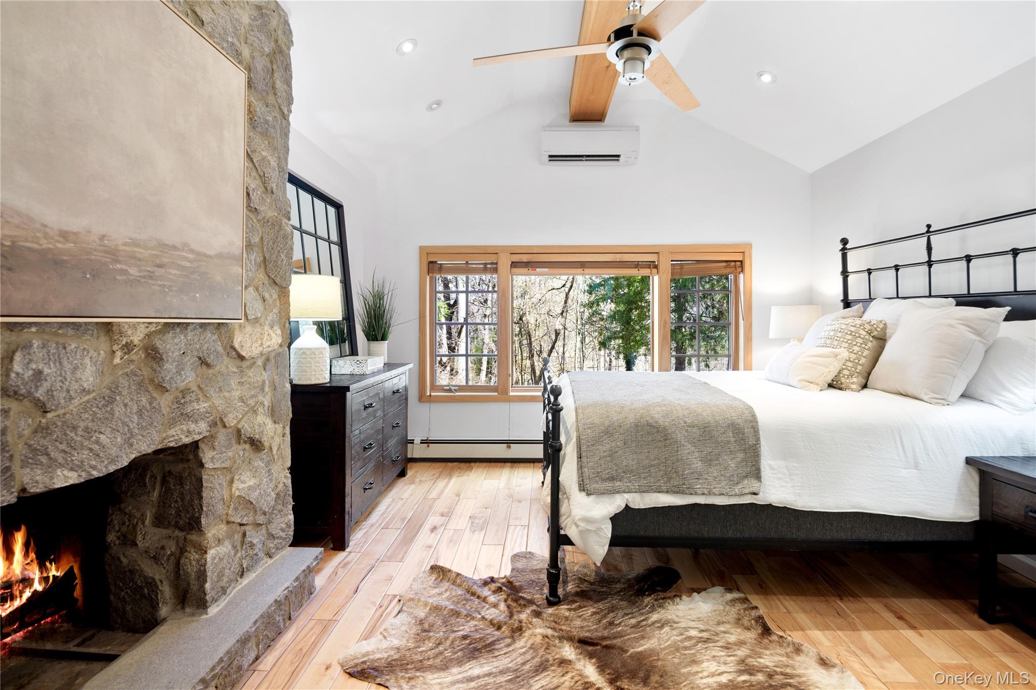 241 West Mt Airy Road Croton-on-Hudson, NY 10520 - Photo 27 of 41 a spacious bedroom with a bed a fireplace and a floor to ceiling window