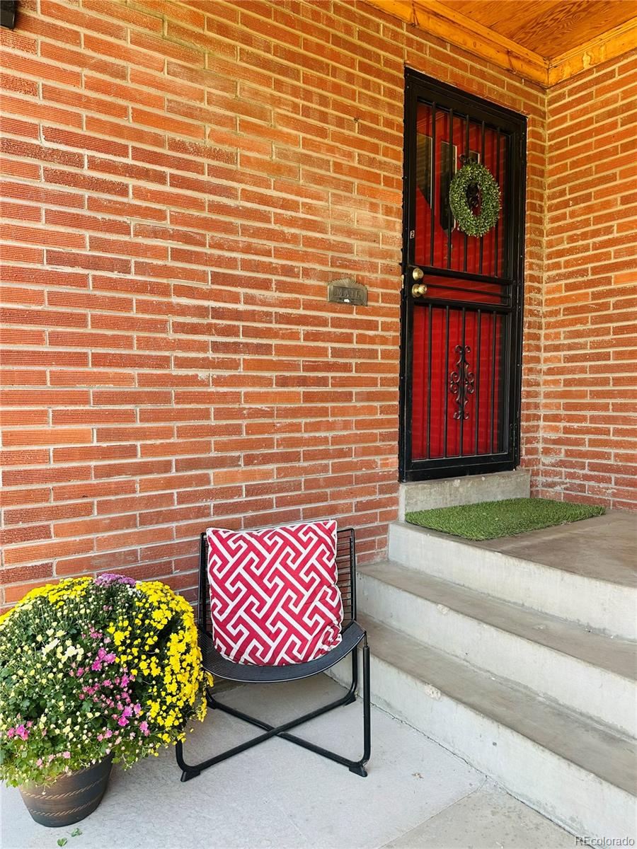 1400 South Clermont Street, Unit 9 Denver, CO 80222 - Photo 2 of 9 a view of a brick wall with a bench in front of red door