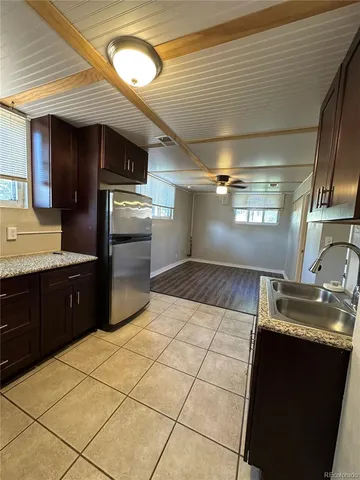 a kitchen with granite countertop a refrigerator and a stove top oven