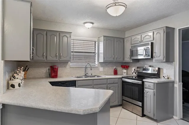 a kitchen with stainless steel appliances granite countertop a sink dishwasher stove and cabinets