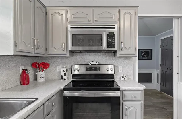 a kitchen with granite countertop cabinets stainless steel appliances and wooden floor