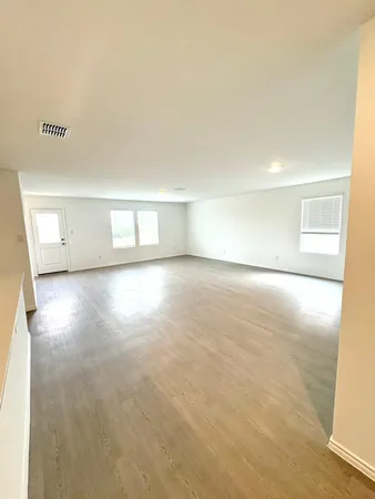 a view of empty room with wooden floor
