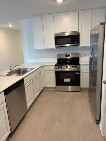 a kitchen with a sink appliances and cabinets