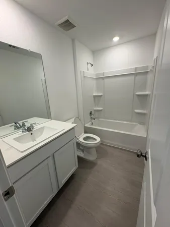 a bathroom with a double vanity sink toilet mirror and shower