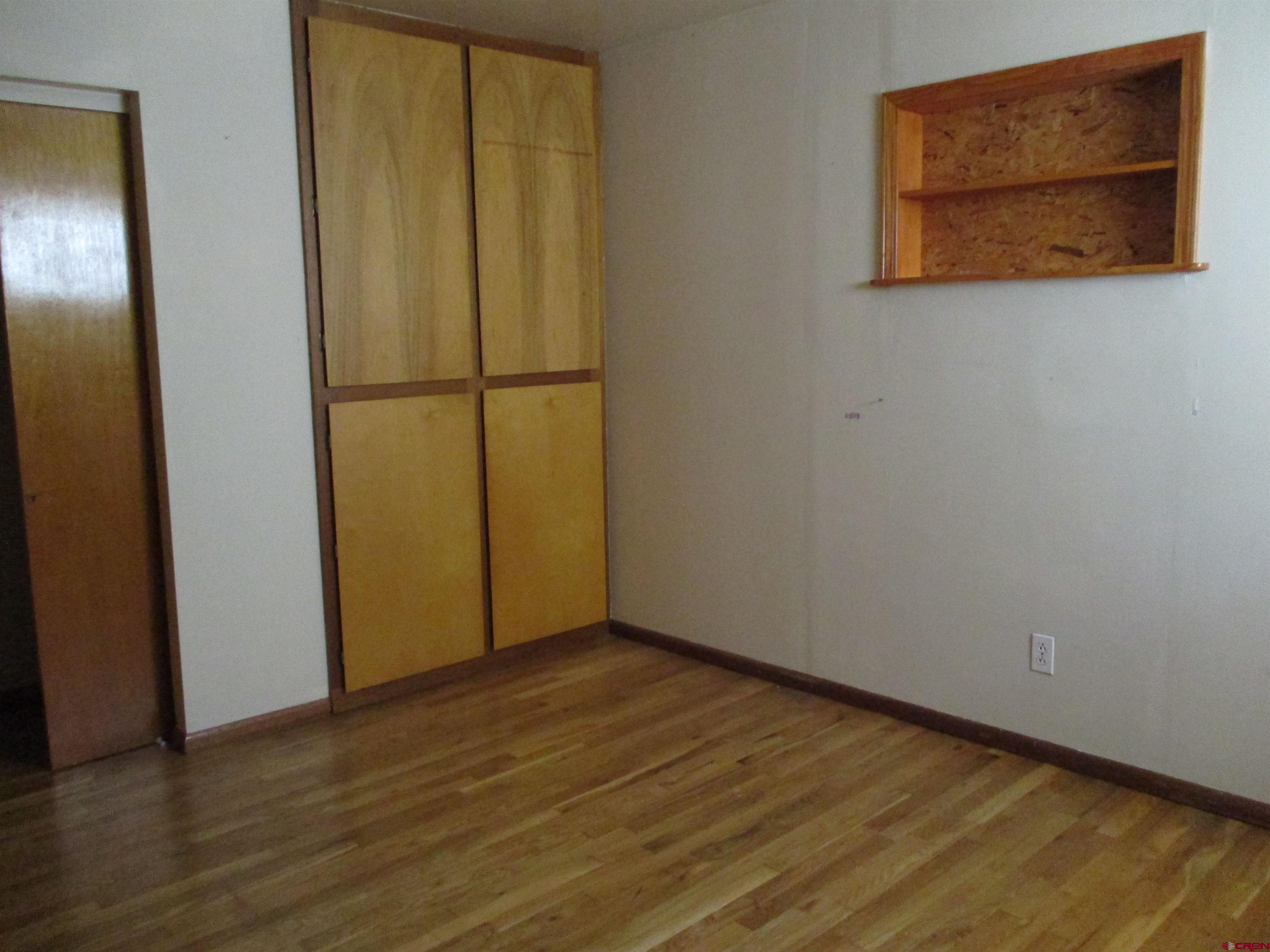 1102 Bluff Street Delta, CO 81416 - Photo 6 of 14 an empty room with wooden floor and closet