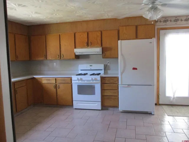 a kitchen with cabinets and white appliances