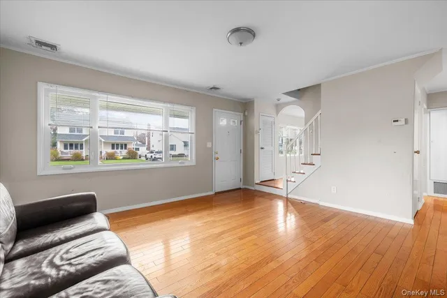 a view of an empty room with window and wooden floor